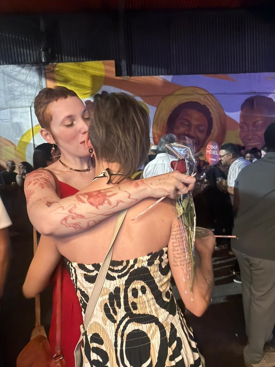 Luísa e Nirvanna se beijando durante uma celebração